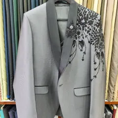 The completed grey designer suit jacket, showcasing the beautiful cascade of black hand embroidery down the shoulder.