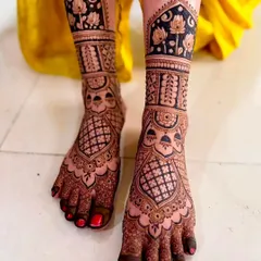 This design features bold lotus motifs against a dark, filled-in background, creating a striking contrast. The intricate patterns cover the entire foot for a complete bridal look.