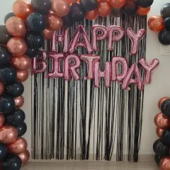 A chic black and rose gold home decor setup. This package includes a shimmer curtain and a balloon frame, instantly creating a festive photo corner in your living room.