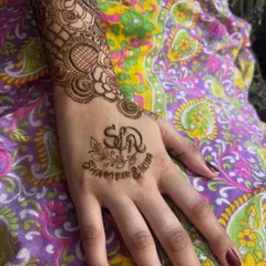 A simple yet elegant personalization on the palm, with the couple's initials and names. The rest of the arm can be filled with intricate patterns or left simple.