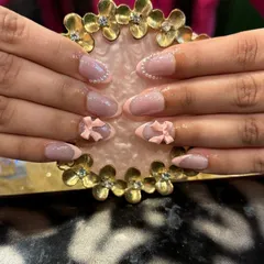 A subtle and sweet look with soft pink 3D bows on a neutral base with a delicate French outline. This shows how 3D elements can be understated and chic.