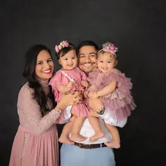 A happy family of four, holding their twin girls close. This classic studio portrait is all about the love and connection that shines through.