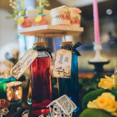 No Wonderland party is complete without a little curiosity. These corked glass bottles filled with colorful drinks and labeled "Drink Me" are a playful and iconic detail that guests love.