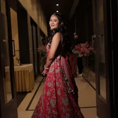 A glamorous and elegant sangeet look that exudes sophistication. The bride is glowing as she makes her entrance, with her makeup perfectly complementing her red outfit.