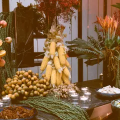 Every detail is a deliberate choice. A sculptural centerpiece made of fresh corn cobs stands beside a bounty of longan fruit, showcasing my method of using natural, edible ingredients as decorative elements within the food styling itself.