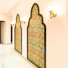 A hallway decorated with arched panels filled with traditional Indian fabric, evoking the feel of a royal haveli.