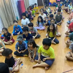 A group of campers sits in a guided meditation, a practice we incorporate to promote mental clarity and relaxation amidst the fun and games.