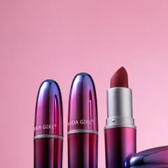 A group shot of Huda Girl lipsticks with their iridescent caps. This composition highlights the product's beautiful design from multiple angles.
