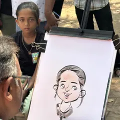 Here you can see me in action, drawing a young girl's portrait as she watches. The live interaction is a key part of the fun.