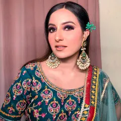 Another angle of this purple smokey eye look. The kohl-rimmed eyes add intensity, while the large chaandbali earrings frame the face and complement the festive, colorful outfit.