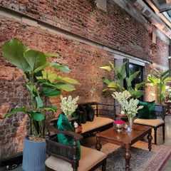 Even the seating areas were integrated into the green decor. Here, we placed tall, large-leafed plants behind traditional wooden furniture, using emerald green cushions to tie the whole look together. This approach ensures every corner of the event feels lush and thoughtfully designed.