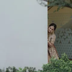 A playful peek from behind a wall, this candid shot captures the bride's joyful and fun-loving personality. It's these unscripted moments that add so much life to a wedding story.
