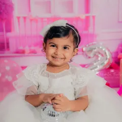 A dazzling smile from a two-year-old princess during her Barbie-themed birthday photoshoot. Her happiness truly lights up the entire studio.