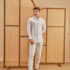 Clean lines, crisp whites, and confidence tailored in. This all-white look, featuring a longline shirt and matching trousers, is the epitome of minimalist, sophisticated style.