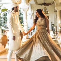 A candid moment of joy and movement. The bride's swirling lehenga and the couple's happy expressions make this a lively and beautiful wedding portrait.