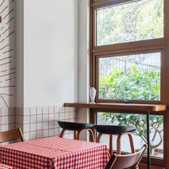 We designed intimate window-side seating for solo diners or pairs. The wooden bar counter and high stools offer a view of the outdoors, while a milkshake on the sill hints at the classic diner experience we aimed to evoke.