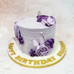 We create a dreamy vision with this lavender butterfly cake. A cascade of purple buttercream roses and delicate, edible butterflies adorns the textured lavender frosting, accented with tiny pearls for a touch of magic and elegance.