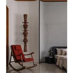 A comfortable rocking chair from Magari sits beside our custom 'Astral' wall totem, creating a quiet corner for reflection. The totem's stacked, turned-wood forms add a vertical, sculptural element that contrasts beautifully with the chair's classic lines.