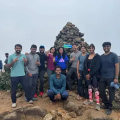 The victorious group at the Kumaraparvatha summit, marked by a pile of stones. Conquering this peak together is an incredible bonding experience.