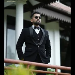 This shot captures the silhouette of the three-piece black tuxedo, showing how the waistcoat and jacket work together for a polished and structured appearance.