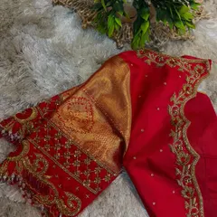 This is the kind of craftsmanship you will learn to create. This vibrant red bridal blouse features intricate gold Aari work along the neckline and sleeves, combined with traditional brocade fabric for a timeless look.