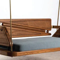 This close-up highlights the intricate hand-chiseled texture on the teakwood frame of our reversible swing. The combination of the detailed woodwork, smooth finish, and plush blue cushion showcases my commitment to fine craftsmanship and material detail.