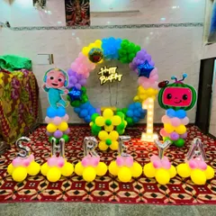 Another fun Cocomelon first birthday, this time with the name "SHREYA" spelled out in balloons. The setup includes a circular balloon arch, character stands, and a light-up '1'.