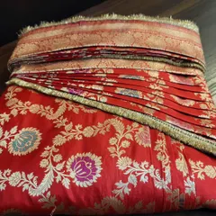 A rich red Banarasi saree, pre-pleated and folded for a bride.