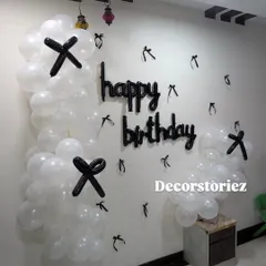 For a minimalist and modern look, I can create simple wall decorations like this one using white balloons with black balloon accents and a 'happy birthday' cutout.