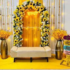 We bring the sunshine to your Haldi ceremony with this cheerful sunflower-themed decor. The setup includes a full floral arch, a bright yellow backdrop with a 'Haldi' neon sign, and matching floral vases, creating a perfect photo opportunity.