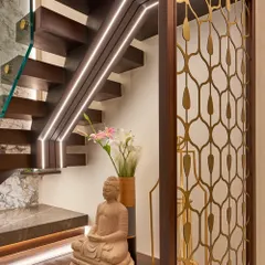 We love to create beautiful moments in transitional spaces. Here, the area under the staircase is transformed with a Buddha statue, elegant vases, and integrated lighting along the steps and handrail.