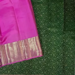 This pure Kanjivaram silk saree features a stunning green brocade body paired with a vibrant pink contrast border and pallu. The intricate weaving and rich colors make it a perfect choice for weddings and grand celebrations.