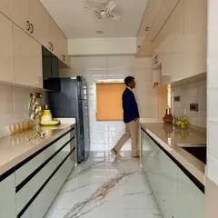 A full view of the galley kitchen, demonstrating its efficient layout. The design ensures everything is within reach, from the stove to the sink to the refrigerator.