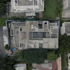 An aerial drone shot of the Courtyard House under construction. This view reveals the complex geometry of the stepping courts and pergolas that are integrated at every level of the home.