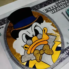 The finished pop art canvas of Scrooge McDuck on a dollar bill, complete with gold and silver glitter details. This piece is perfect for adding a touch of luxury and fun to any interior.