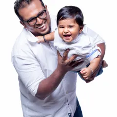 The pure happiness of a father and son playing together. This classic studio portrait on a white background captures a beautiful, candid moment of laughter.