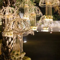 Beautiful crystal and floral kaleeras hanging from a palm tree. This is an example of how I creatively incorporate traditional elements into outdoor, modern decor.