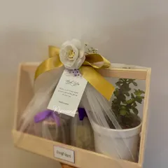 A closer look at our popular wedding return favor. This hamper includes a jade succulent plant, a jar of cookies, a jar of chocolates, a scented candle, and potpourri, all in a stylish wooden crate.