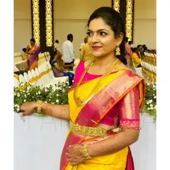 This client looks radiant in her bright yellow and pink saree, paired with a custom-designed pink blouse. The blouse features intricate embroidery on the sleeves for a touch of sparkle.