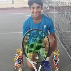 A double victory for Tavish Pahwa at the Asian Grade A Tennis Tournament in Malaysia. He proudly holds his trophies for winning both the Under 14 Singles and Doubles titles, a remarkable feat of skill and endurance.