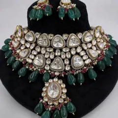 A close-up of the Polki necklace set with triangular stones, showing the intricate details and ruby accents.