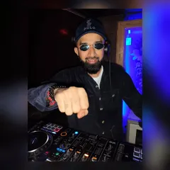 A confident pose behind the decks. I believe that a DJ's presence and energy are just as important as the music they play.