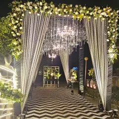 This black and white themed entrance makes a bold statement. It features a chevron-patterned carpet, drapes with a geometric print, and a stunning crystal chandelier, leading guests into a glamorous cocktail event.