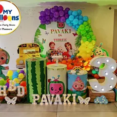 A vibrant and playful Cocomelon theme for a third birthday party. This colorful setup features a rainbow balloon arch, character cutouts, themed plinths, and large light-up numbers, making it a dream come true for any little Cocomelon fan.