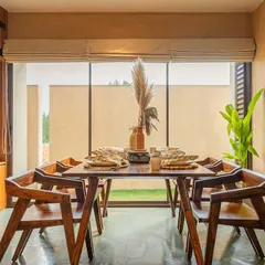 In the dining area of the Terravana Villa, I blurred the line between indoors and outdoors. The space opens to a landscaped niche, and the green Kota stone floor extends the feeling of the garden inside. The exposed concrete light fixture emphasizes the raw, honest materiality that defines this home.