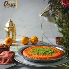 A beautifully styled shot of my freshly made Kunafa, generously sprinkled with pistachio and drizzled with syrup. It's a classic Middle Eastern dessert that I am proud to serve.