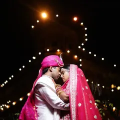 A romantic silhouette of the couple against a backdrop of festive lights, creating a dreamy and intimate wedding portrait.