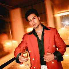 A toast to style. This rust-colored double-breasted blazer, paired with a deep green shirt and off-white trousers, makes a bold statement for any celebration.
