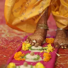 A beautiful moment from a wedding ceremony, capturing the bride's feet adorned with intricate mehendi as she participates in the rituals.
