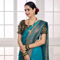 A close-up shot focusing on the model's expression and the fine details of a gold mangalsutra and matching earrings. The soft lighting and traditional attire make this perfect for showcasing wedding jewellery collections.